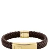 Brunt flätat läderarmband med guldfärgad logotyp